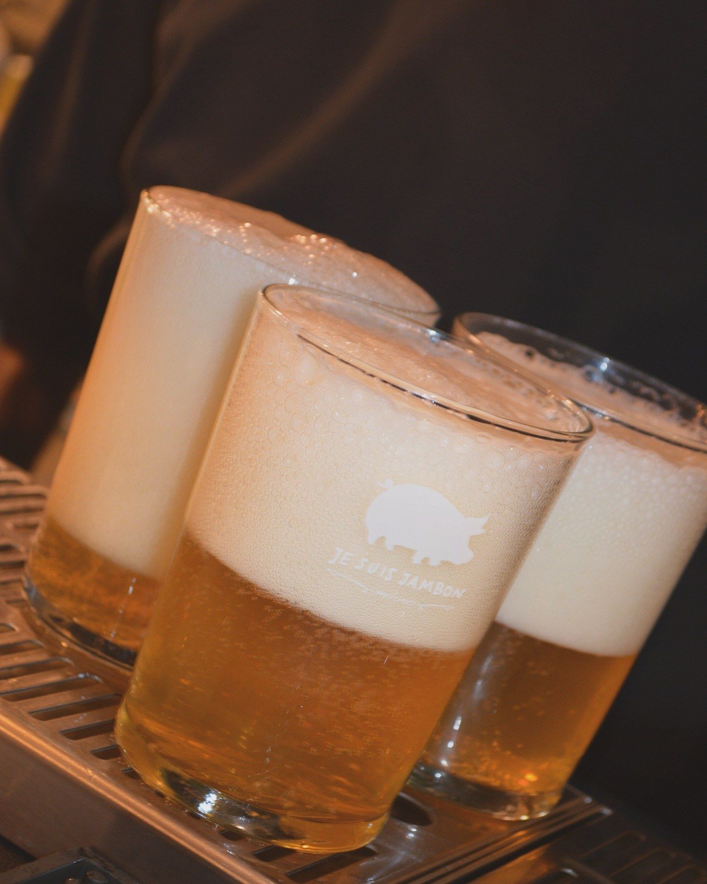 Tre birre chiare alla spina appena spillate, con il maiale di Je Suis Jambon stampato sul bicchiere