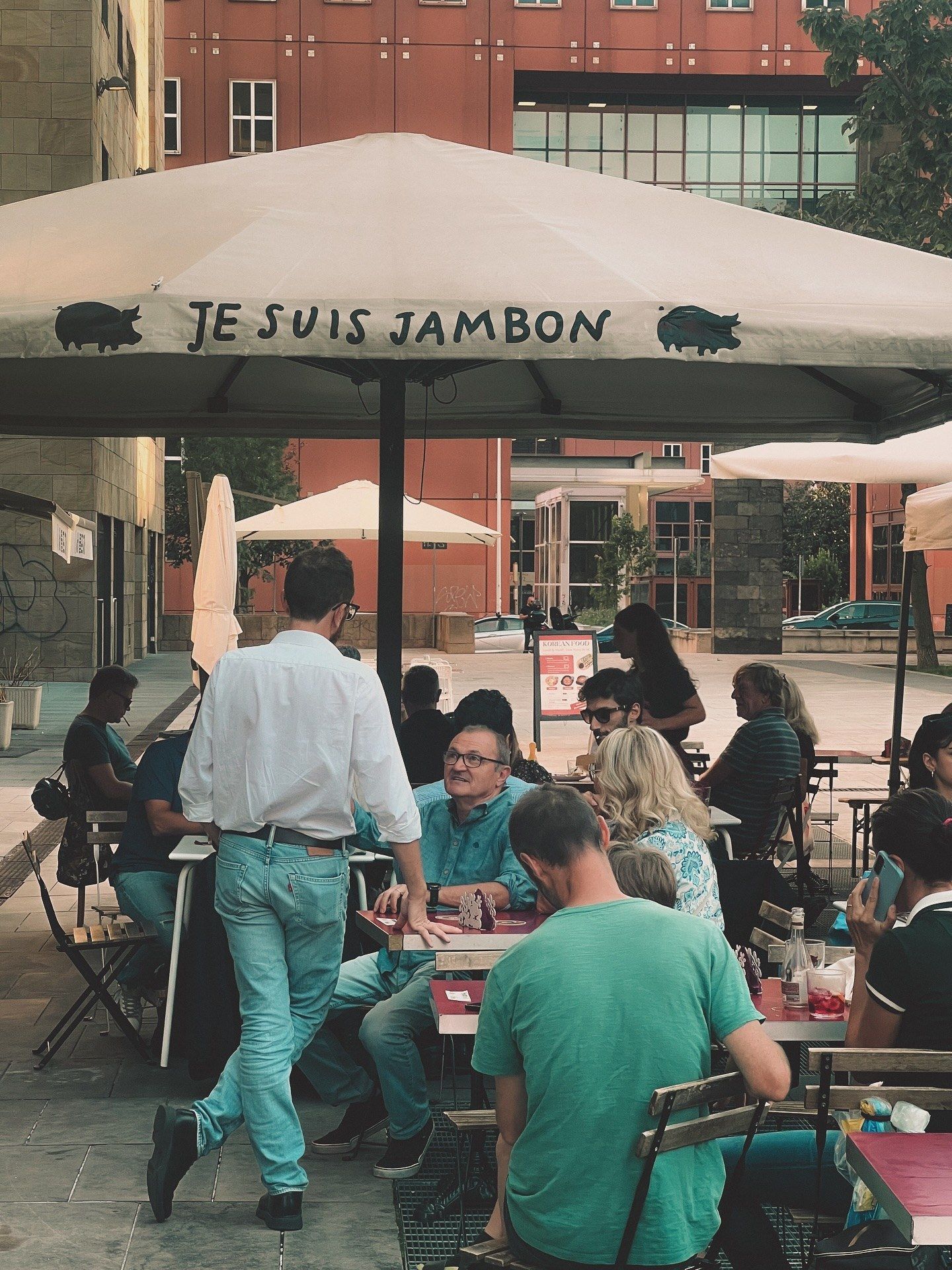 Tavoli all’aperto sotto l’ombrellone con la scritta Je Suis Jambon