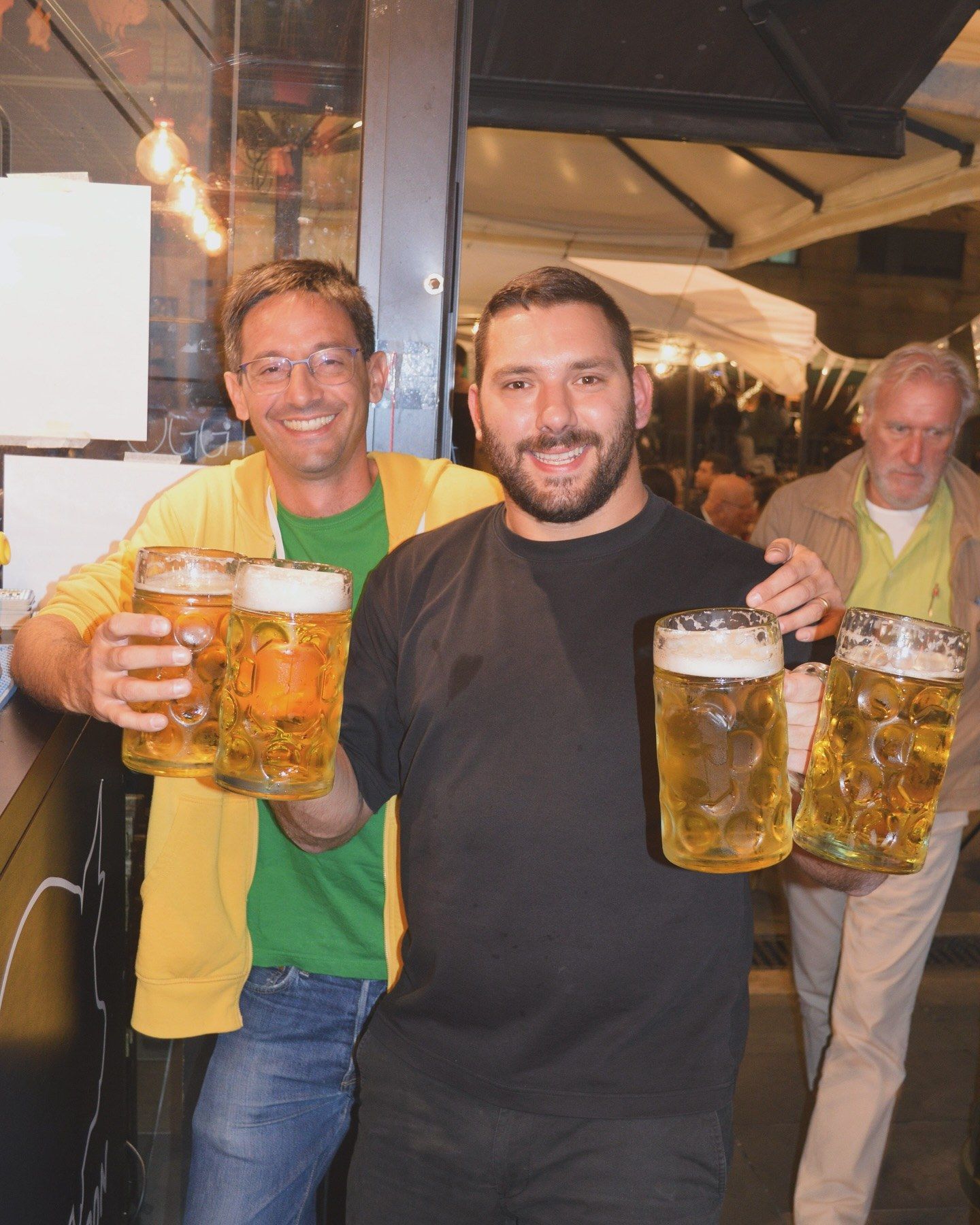 Amici che brindano con boccali da un litro all’Oktoberpork